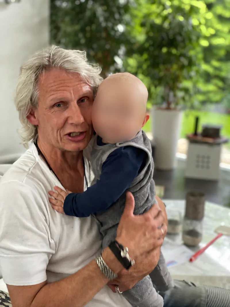 Karsten mit einem Baby; Gesicht des Kindes unkenntlich gemacht