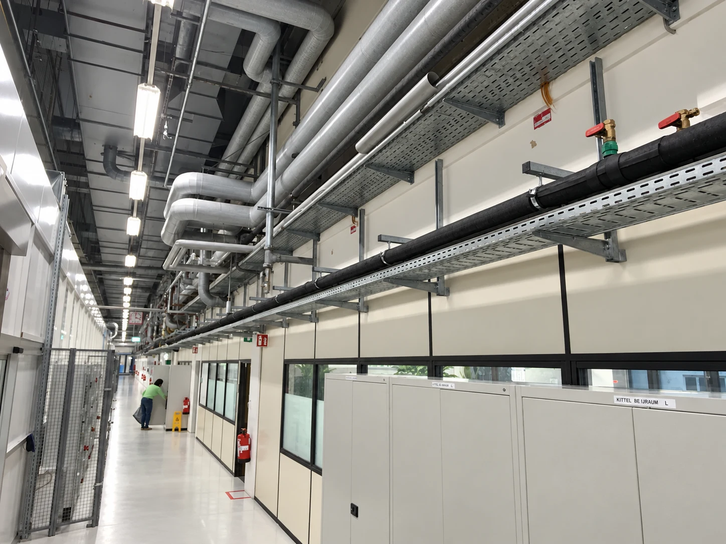 Technischer Gang mit Leitungen, Rohren und Lüftungskanälen verschiedener Gewerke